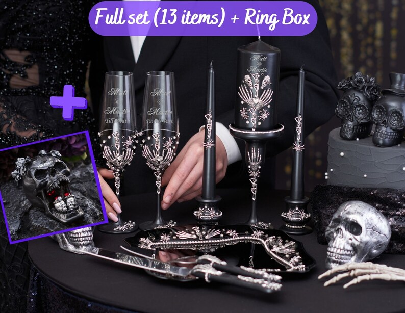May include: A full set of gothic wedding decor, including champagne flutes, candles, and a ring box. The set features a black and silver color scheme with skeleton and skull motifs. The text on the champagne flutes reads "Matt & Martie Till Death Do Us Part."