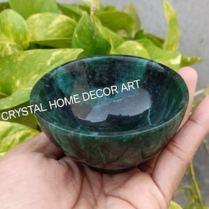 Könnte beinhalten: Eine kleine, grüne Marmor-Schale mit einem wirbelnden Muster. Die Schale wird in einer Hand gehalten.  "CRYSTAL HOME DECOR ART" steht auf der Schale.