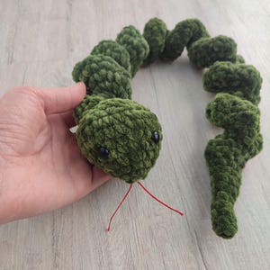 Peut inclure: Un jouet serpent en crochet vert avec des yeux noirs et du fil rouge pour la langue.