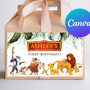 Op de afbeelding: Een bruine geschenkdoos met een roze lint en een label met personages uit The Lion King. Het label luidt "Ashley's First Birthday!" en bevat illustraties van Simba, Timon, Pumbaa en andere personages.
