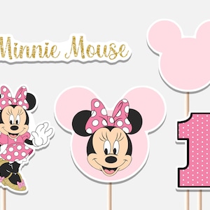 Può includere: Una collezione di decorazioni per feste a tema Minnie Mouse. Include un ritaglio di Minnie Mouse, una silhouette di orecchio di topo rosa, un numero uno rosa a pois bianchi e un testo glitterato dorato "Minnie Mouse".