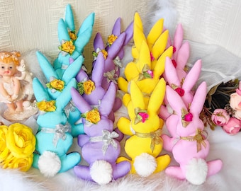 May include: A group of 10 pastel colored felt bunny rabbit decorations with flower accents. The bunnies are in shades of blue, yellow, pink, and purple.