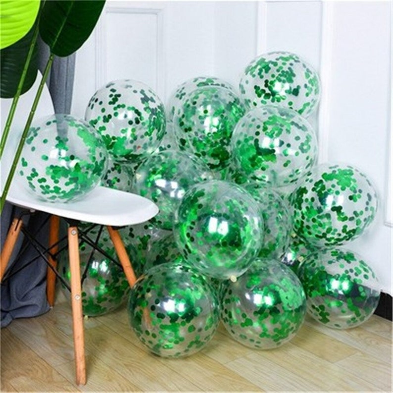 May include: A group of clear balloons filled with green confetti. The balloons are arranged in a cluster and are partially overlapping.