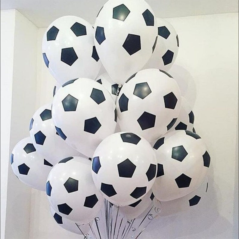 Może przedstawiać: Stos biało-czarnych balon&oacute;w w kształcie piłki nożnej. Balony są ułożone w stos, niekt&oacute;re z nich się nakładają.