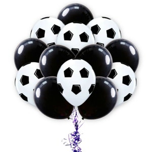 Może przedstawiać: Gromada czarno-białych balon&oacute;w w kształcie piłki nożnej. Balony są związane razem purpurową wstążką.