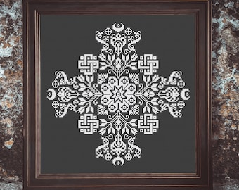 Puede incluir: Un diseño de punto de cruz en blanco y negro enmarcado con un patrón geométrico en el centro y motivos florales alrededor de los bordes. El diseño está sobre un fondo gris oscuro.