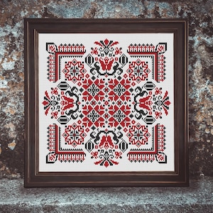 May include: A framed cross-stitch embroidery with a geometric pattern in red, black, and white. The design features stylized flowers and leaves.