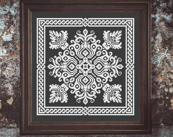 Puede incluir: Un patrón de punto de cruz enmarcado con un diseño floral blanco sobre un fondo verde oscuro. El marco es de madera marrón oscura.