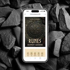 Könnte beinhalten: Ein Smartphone zeigt das Cover eines Buches mit dem Titel "RUNES BEGINNER'S GUIDEBOOK" und dem Text "ELDER FUTHARK". Das Cover zeigt ein kreisförmiges Design mit Runensymbolen. Das Telefon befindet sich vor einem Hintergrund aus dunkelgrauen Steinen.