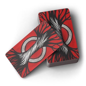 Puede incluir: Dos cartas de juego rojas con ilustraciones en blanco y negro de &aacute;rboles con un c&iacute;rculo rojo y blanco en el centro. Las cartas est&aacute;n apiladas una encima de la otra.