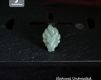 Op de afbeelding: Een lichtgroene jadeïet vossen hanger. De hanger is gesneden met gedetailleerde kenmerken en is gelabeld "Natural Untreated Burmese Jadeite Fox". De hanger wordt gepresenteerd op een donkere ondergrond.
