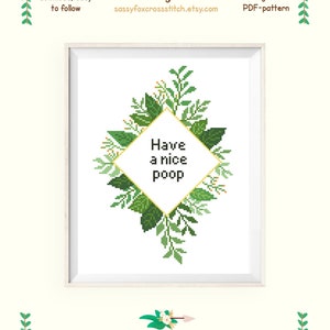 May include: Cross stitch pattern featuring a green leafy border with a diamond-shaped frame that says "Have a nice poop". The pattern is for Aida 14 count fabric and measures 6.3 by 8.9 inches (16.0 by 22.7 cm).