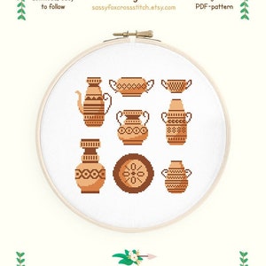 Könnte beinhalten: Kreuzstichmuster mit acht braunen und orangefarbenen Keramikdesigns, darunter Vasen, Schalen und ein Teller. Das Muster ist für Aida 14 Stoff und misst 17,4 cm x 17,6 cm. Das Muster verwendet 3 Farben und wurde von Sassy Fox entworfen.