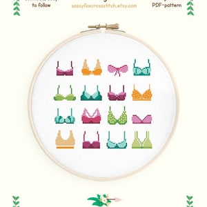 Puede incluir: Un patrón de punto de cruz con una variedad de sujetadores coloridos, con un zorro con un tocado en la esquina superior izquierda. El patrón es para tela Aida 14 y mide 18,5 cm por 16,9 cm. El patrón utiliza 14 colores y está diseñado por Sassy Fox.