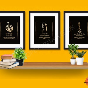 Op de afbeelding: Drie ingelijste kunstdrukken met zwarte achtergronden en gouden symbolen en tekst. De prints zijn gelabeld met "Cho Ku Rei", "Sei He Ki" en "Hon Sha Ze Sho Nen". De prints worden getoond op een houten plank met planten en boeken.