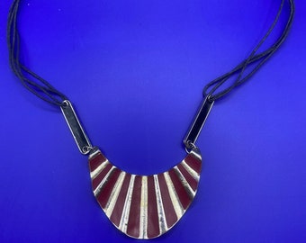 Anhänger im Boho-Stil auf einem schwarz emaillierten roten Metallic-Kordelanhänger.