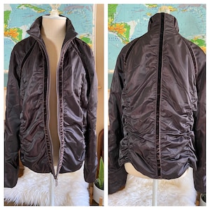 May include: A brown quilted jacket with velvet trim. The jacket has a zipper closure and a stand-up collar.