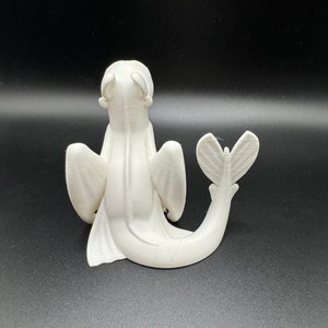 May include: White 3D printed figurine of a dragon with wings and a tail. The dragon is sitting on its hind legs with its head tilted back.