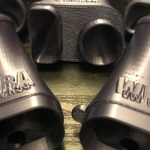 May include: Four 3D printed purple plastic exhaust tips with the word "WARA" printed on each.