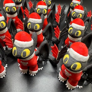 May include: A group of black and red Christmas ornaments shaped like dragons. The ornaments have yellow eyes and white accents.