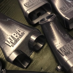 May include: A close-up of five gray plastic 3D printed parts with the word "WARBA" printed on each part. The parts are shaped like funnels or cones.