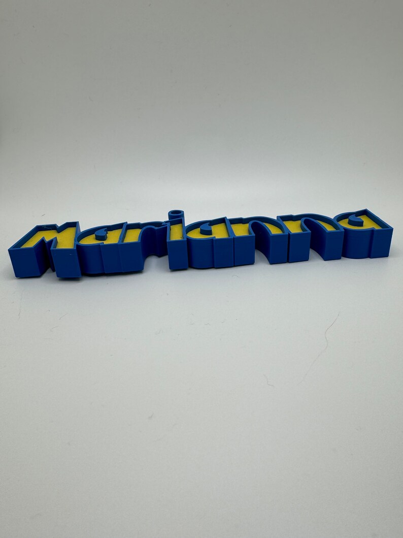 May include: A blue and yellow 3D name sign that reads "mariana".