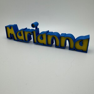 May include: A blue and yellow 3D name sign that reads "Marianna".