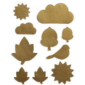 May include: A set of ten gold-colored paper cutouts in the shapes of a sun, clouds, leaves, a bird, and a star. The cutouts are all on a white background.