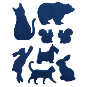 May include: A set of nine blue felt animal silhouettes, including a bear, cat, rabbit, squirrel, and dog. The silhouettes are cut out and ready to be used for crafts or decorations.