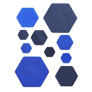 Puede incluir: Una colección de formas hexagonales azules y azul oscuro de diferentes tamaños. Las formas están dispuestas en un patrón aleatorio sobre un fondo blanco.