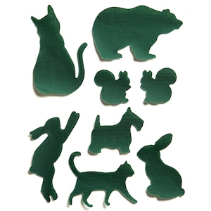 Könnte beinhalten: Grüne Filz-Ausschnitte verschiedener Tiere, darunter ein Bär, eine Katze, ein Kaninchen, ein Eichhörnchen und ein Hund. Die Ausschnitte befinden sich auf weißem Hintergrund.