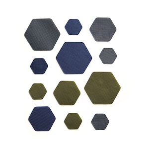 May include: A collection of 12 hexagonal fabric wall tiles in various shades of blue, green, and grey. The tiles are arranged in a geometric pattern.