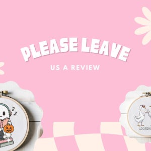 May include: Pink background with the text "PLEASE LEAVE US A REVIEW". Two cross-stitch hoops are displayed. One features a ghost reading with a black cat and pumpkin. The other shows two geese with the word "GOOSEBUMP".