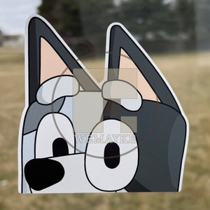 May include: A die-cut vinyl sticker featuring a cartoon dog character with large oval eyes, a black nose, and pointed ears. The character has a color palette of dark gray, light gray, and white. The text WEMAYKE is printed in white on the sticker.