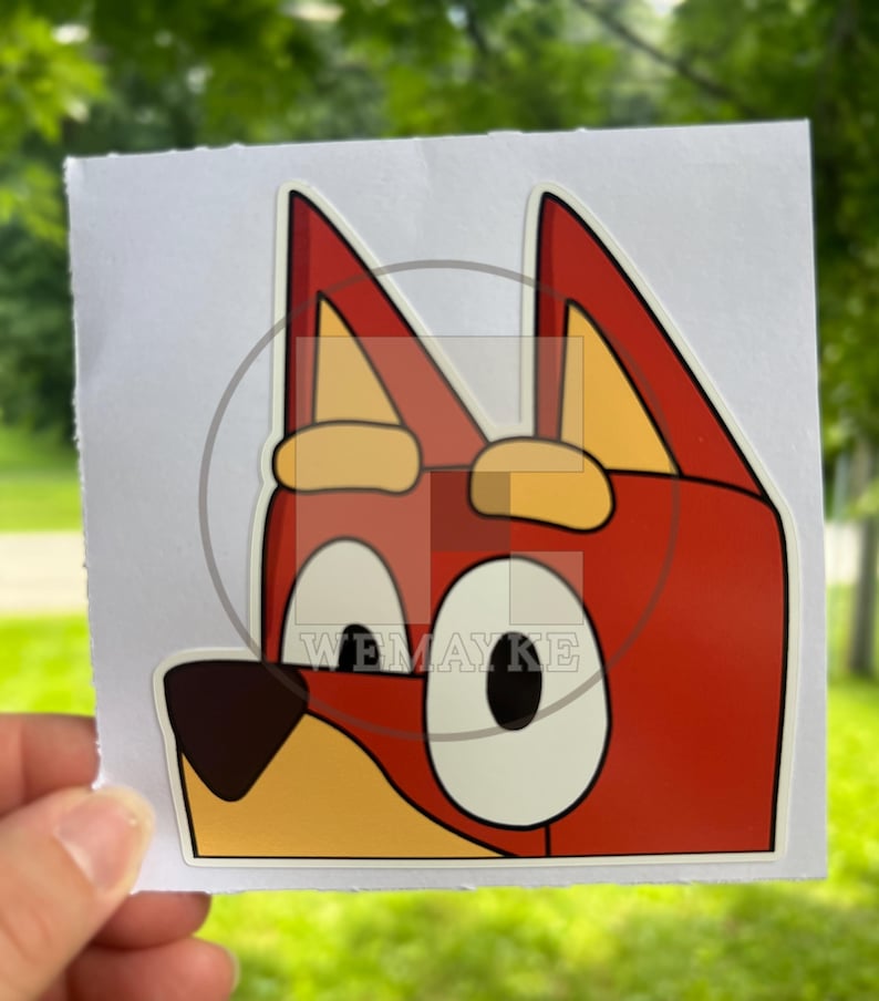 May include: A square sticker featuring a cartoon dog character with red fur, large white eyes with black pupils, a dark brown nose, and yellow inner ears. The character has pointed ears and a light yellow muzzle. The text WEMAYKE is visible.