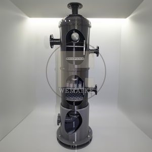 May include: A vertical industrial filtration unit in dark gray with a lighter gray base. The cylindrical structure features multiple cutaway sections revealing internal components, including a grid and piping. The text WEMAYKE is visible.