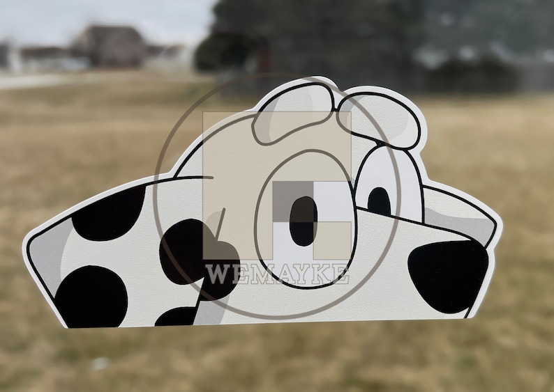 May include: A flat, die-cut sticker featuring a cartoon dog head with white fur, black spots, and large eyes. The design includes a black nose and ears, with the text WEMAYKE printed in white letters over a square watermark overlaying the center.