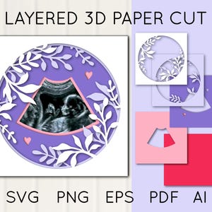 May include: A layered 3D paper cut design featuring a baby ultrasound image within a purple circle, adorned with white floral elements and small pink hearts. Additional cut-out shapes in pink and purple are also shown.