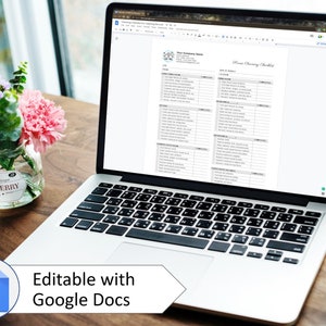 May include: A laptop computer displaying a printable home cleaning checklist in Google Docs. The checklist includes a variety of cleaning tasks for different rooms in the house. The laptop is on a wooden table with a vase of flowers.