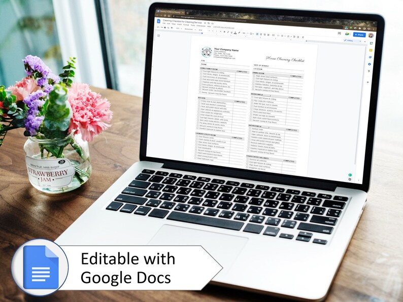 May include: A laptop computer displaying a printable home cleaning checklist in Google Docs. The checklist includes a variety of cleaning tasks for different rooms in the house. The laptop is on a wooden table with a vase of flowers.