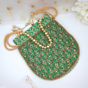 Puede incluir: Un bolso de mano verde y dorado bordado con cierre de cord&oacute;n de cuentas. El bolso est&aacute; decorado con un patr&oacute;n geom&eacute;trico y tiene una correa de cadena dorada.