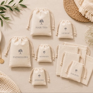 May include: A collection of off-white drawstring pouches in various sizes, each featuring a black palm tree icon and text labels including HAIR TIES, LIP BALM, PAINKILLERS, ROOM KEY, EAR BUDS, and JEWELLERY, arranged on a neutral surface.