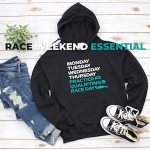 Puede incluir: Una sudadera negra con capucha que presenta texto blanco con los d&iacute;as de la semana de lunes a jueves, seguido de texto en color verde azulado que dice PRACTICE, QUALIFYING y RACE DAY, junto a iconos de un casco y un coche de carreras.