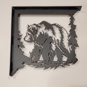 May include: Black metal shelf bracket with a cut-out design of a bear and pine trees.