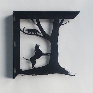 May include: Black metal shelf bracket with a silhouette of a dog standing on its hind legs and a raccoon running up a tree.