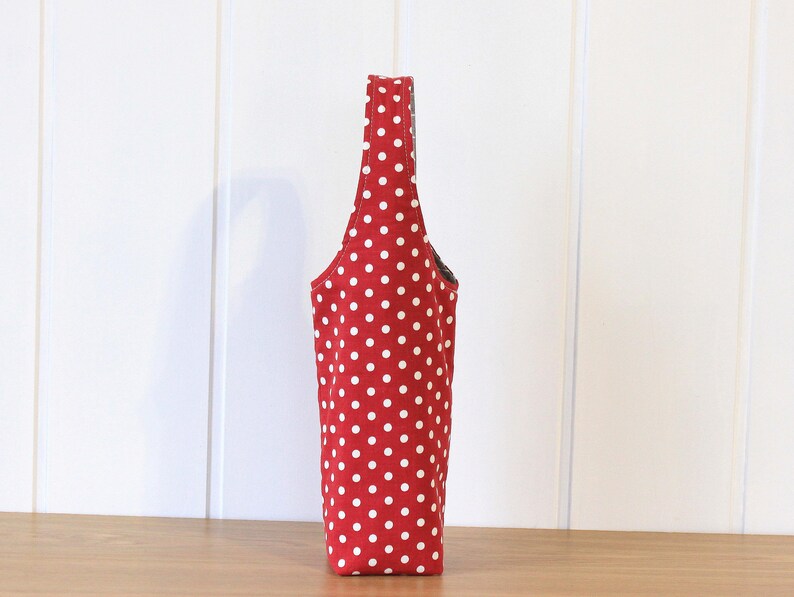 May include: A red and white polka dot tote bag with a black handle.