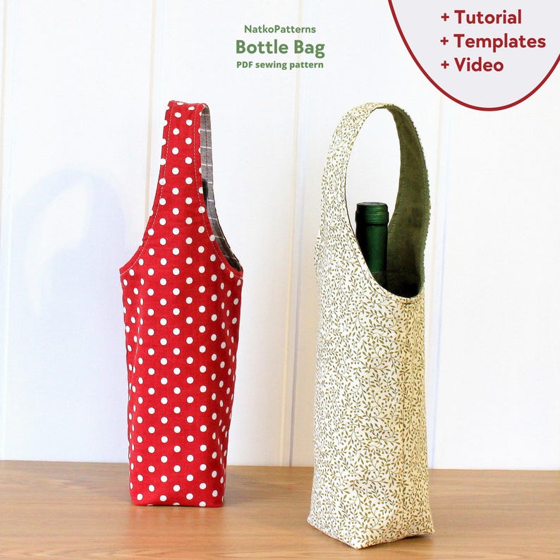 May include: Two fabric bottle bags, one red with white polka dots and one cream with green leaf print. Both bags have a handle and are designed to hold a bottle of wine or other beverage.