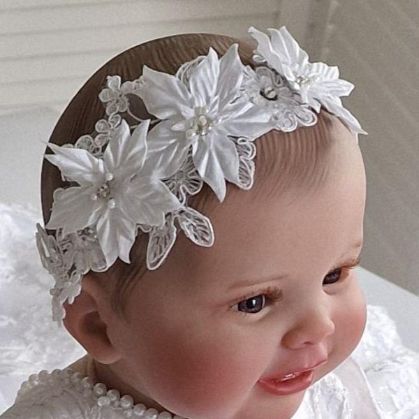 A delicate headband with voluminous white flowers embroidered with beads and rhinestones.