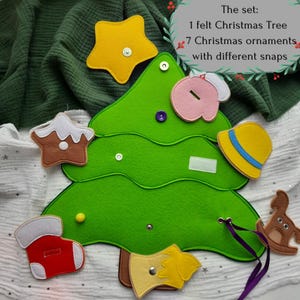 May include: A green felt Christmas tree with seven colorful ornaments, including a star, a stocking, and a hat. The set includes a felt Christmas tree and seven ornaments with different snaps. The text reads: "The set: 1 felt Christmas Tree 7 Christmas ornaments with different snaps."