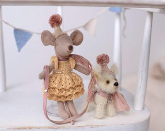 May include: Two handmade fabric dolls: a mouse in a yellow dress and a small dog, both wearing party hats and pink accessories. The mouse doll holds a pink leash. Decorative bunting is in the background.